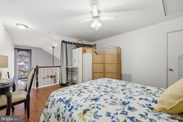 a bedroom with a bed next to a window and a chandelier