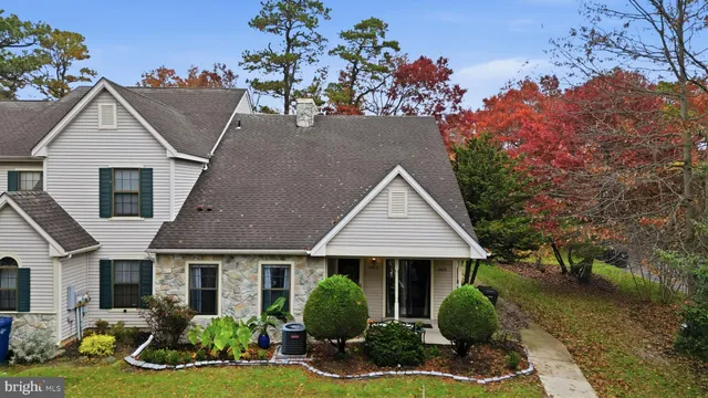 a front view of a house with a yard and potted plants
