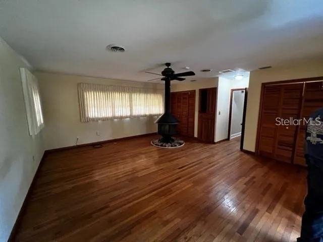 a view of empty room with wooden floor and window