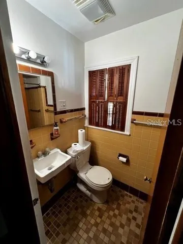 a bathroom with a sink a toilet and mirror
