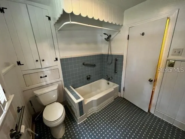 a bathroom with a granite countertop toilet and a shower