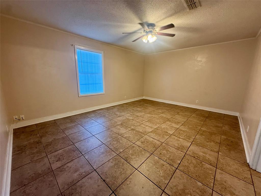 217 3rd St Pinehill Springhill, LA 71075 - Photo 17 of 23 Spacious room featuring neutral wall tones, large format ceramic tile flooring, a window with horizontal blinds, a ceiling fan with integrated lighting, and white baseboards