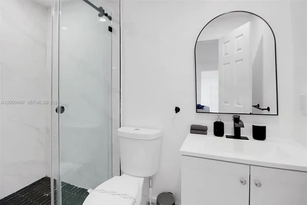 a bathroom with a sink a toilet and a mirror