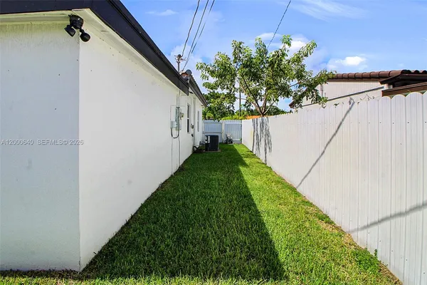 a view of a backyard with wooden fence