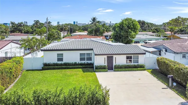 a view of a house with a yard and potted plants