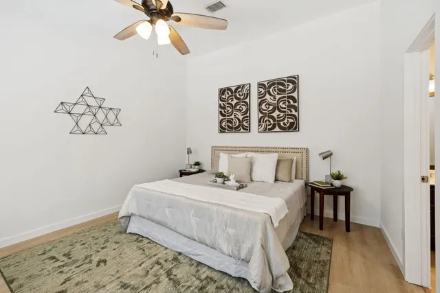a bedroom with a bed and wooden floor