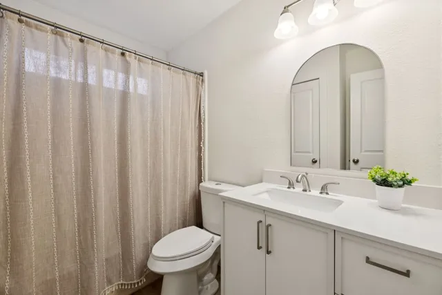 a bathroom with a sink mirror and toilet