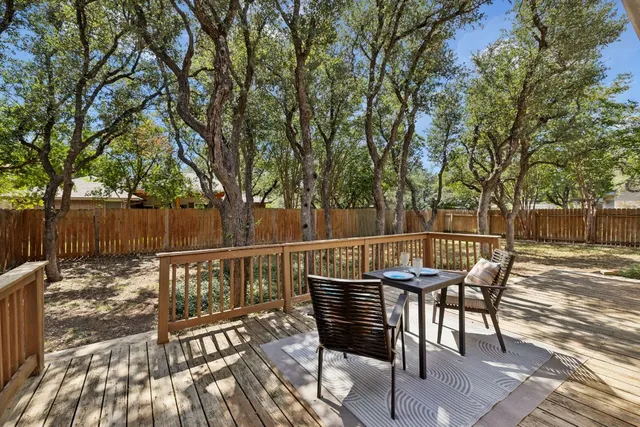 a view of a roof deck with table and chairs and wooden floor