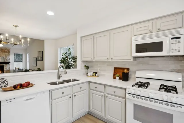 a kitchen with white cabinets and white appliances