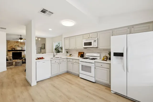 a kitchen with white cabinets and white appliances