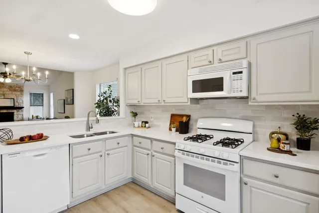 a kitchen with white cabinets and white appliances