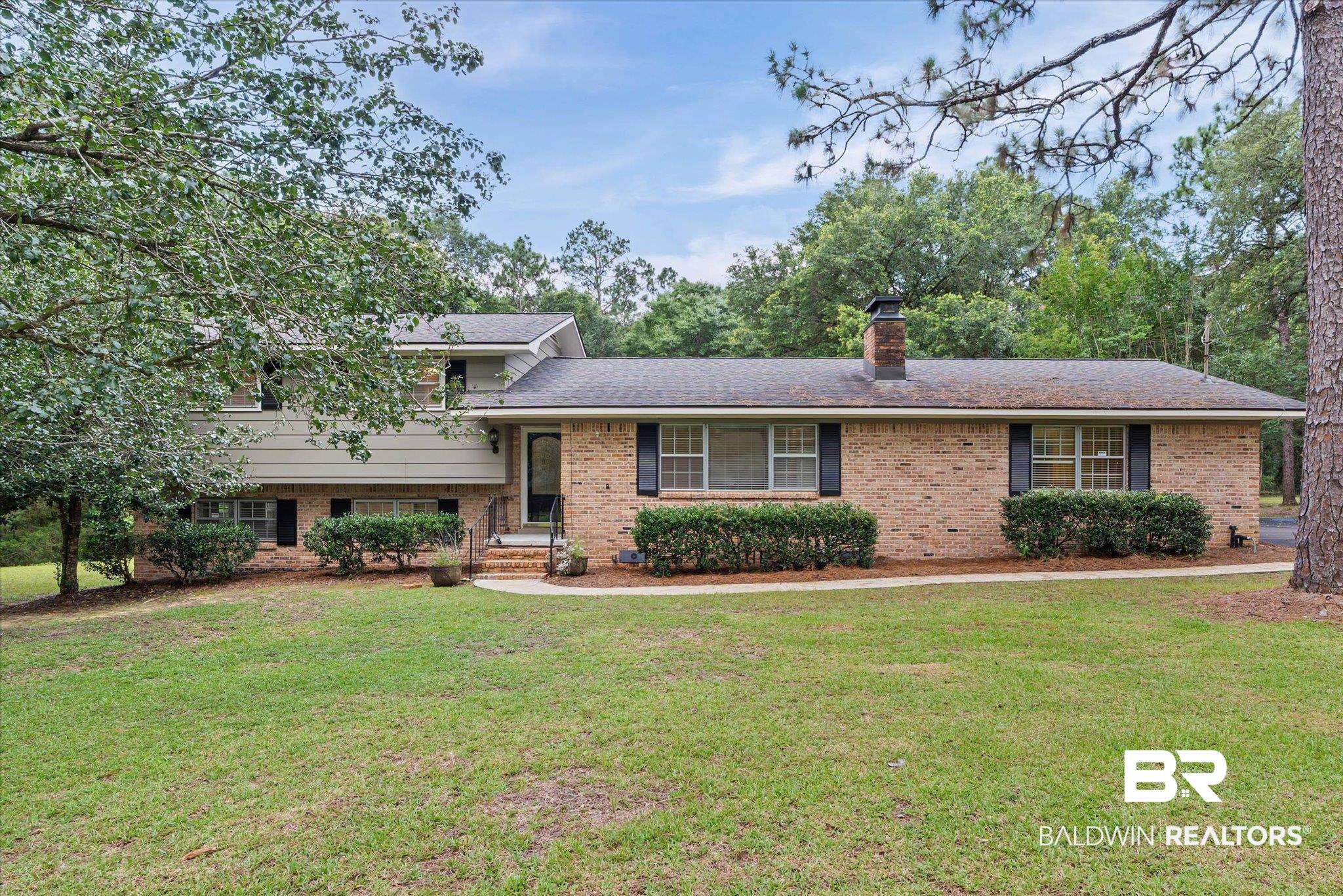 8301 Fordham Road Mobile, AL 36619 - Photo 1 of 57 Brick and siding facade home featuring a chimney, black shutters, and mature landscaping