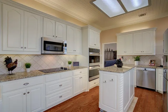 a kitchen with appliances a sink and cabinets
