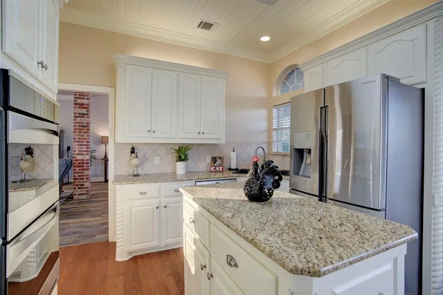 a kitchen with stainless steel appliances granite countertop a sink refrigerator and cabinets