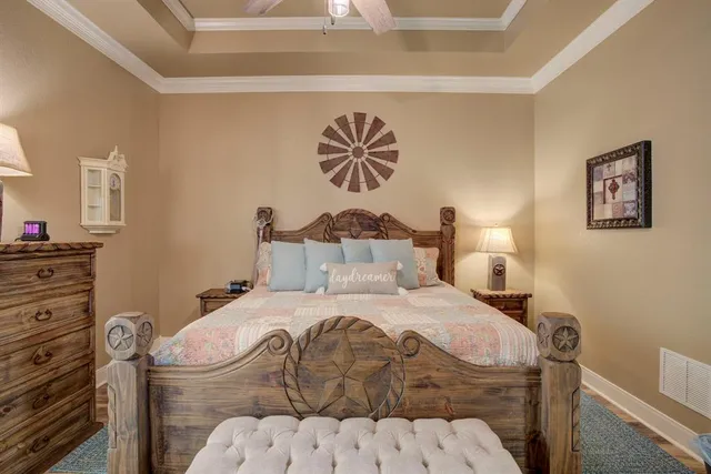 a bedroom with a bed and a lamp on dresser