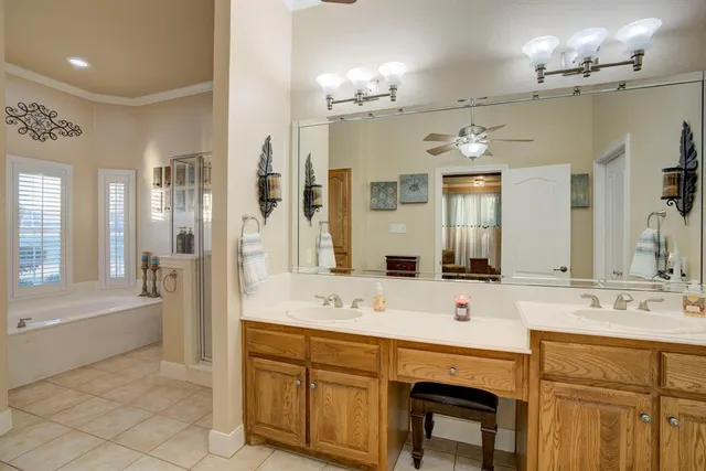 a spacious bathroom with a sink double vanity granite tub shower and a mirror