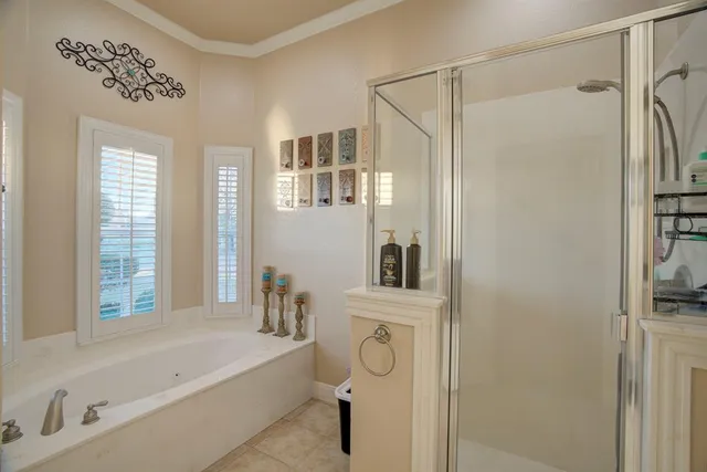 a bathroom with a bathtub a shower a sink and a window