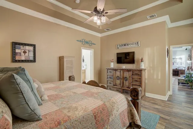 a spacious bedroom with a bed and a flat screen tv