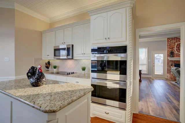 a kitchen with stainless steel appliances kitchen island granite countertop a stove and a sink