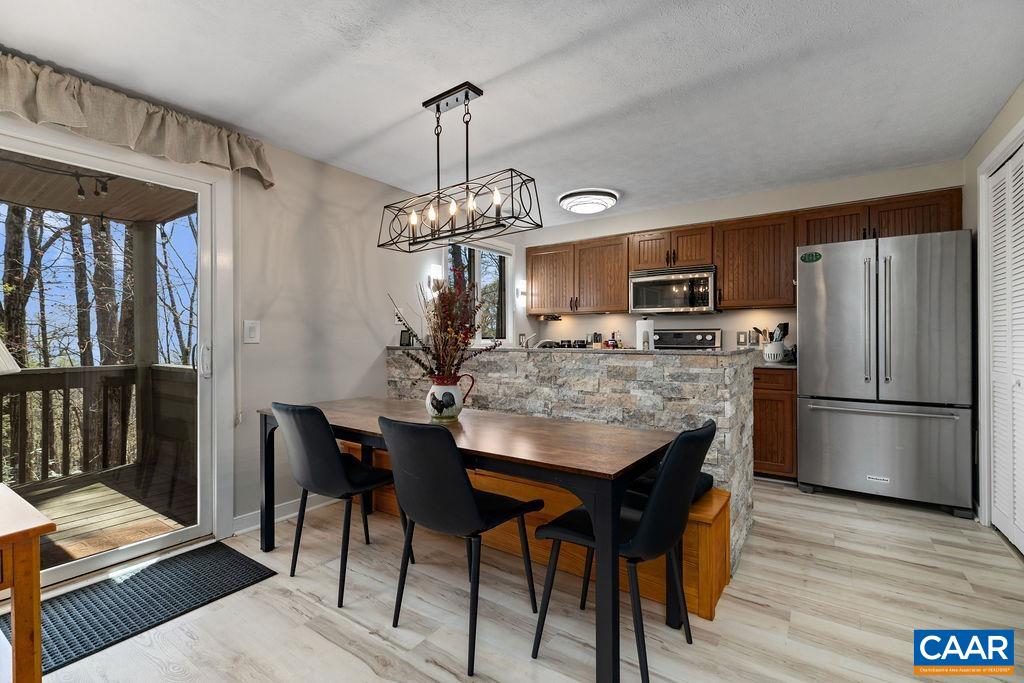 405 3 Ridges Roseland, VA 22967 - Photo 7 of 22 a kitchen with stainless steel appliances granite countertop a refrigerator a stove a microwave a dining table and chairs with wooden floor