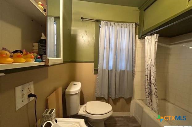 419 West Main Street Lometa, TX 76853 - Photo 12 of 16 a white toilet sitting next to a bathroom sink and a shower