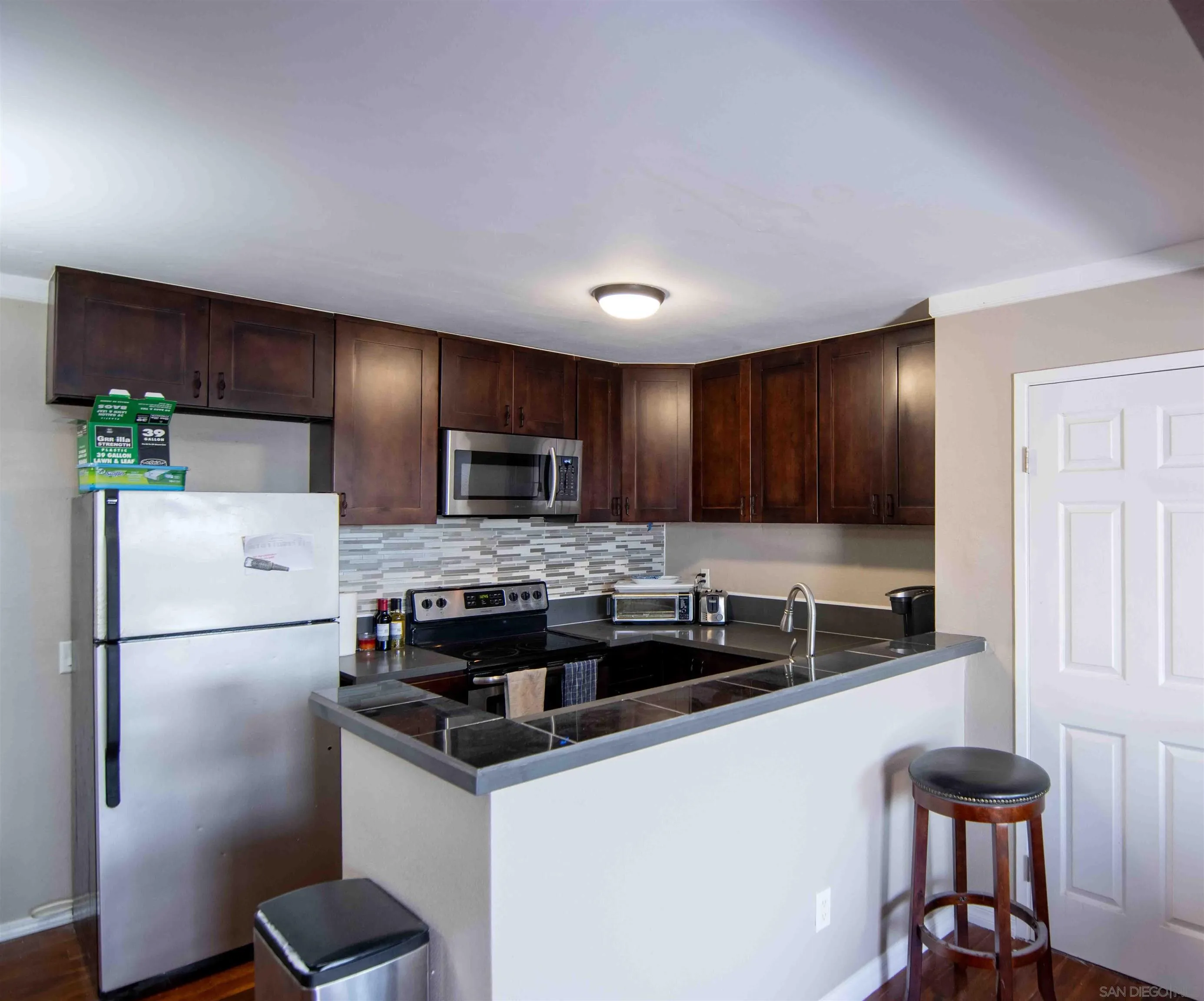 3550 Ruffin Road, Unit 145 San Diego, CA 92123 - Photo 9 of 26 a kitchen with stainless steel appliances granite countertop a refrigerator a stove a sink and a microwave