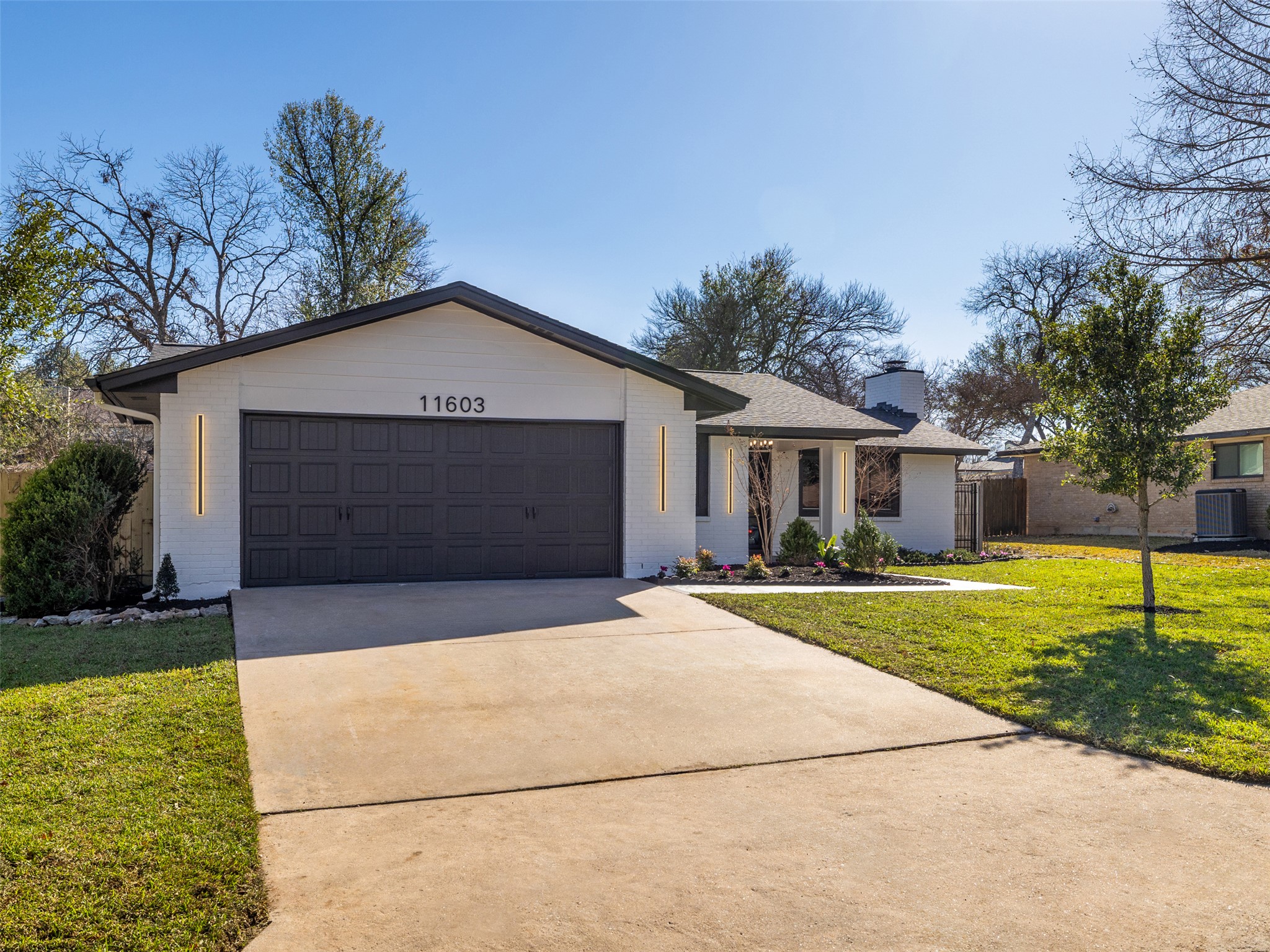11603 Buckingham Road Austin, TX 78759 - Photo 1 of 1 Single story home with a front lawn, driveway, brick siding, and a chimney