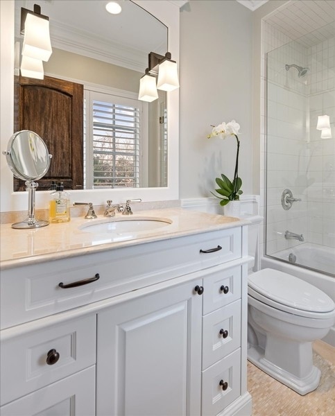 1045 Starr Road Winnetka, IL 60093 - Photo 31 of 57 a bathroom with a granite countertop toilet sink and mirror