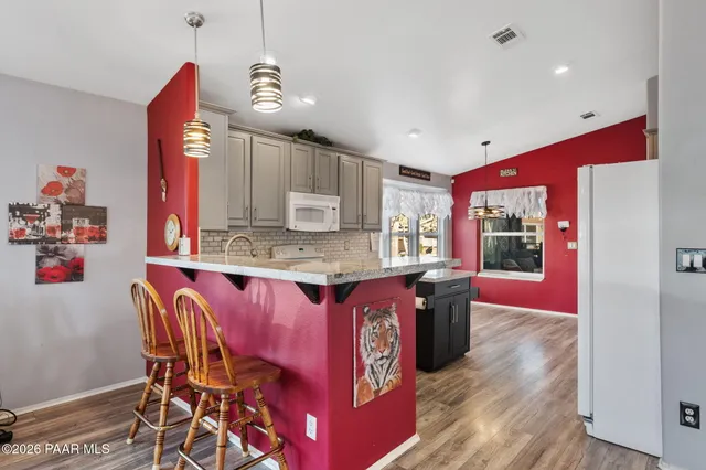 a kitchen with stainless steel appliances granite countertop a kitchen island and a refrigerator