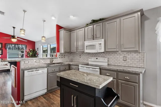 a kitchen with stainless steel appliances granite countertop a sink stove and cabinets