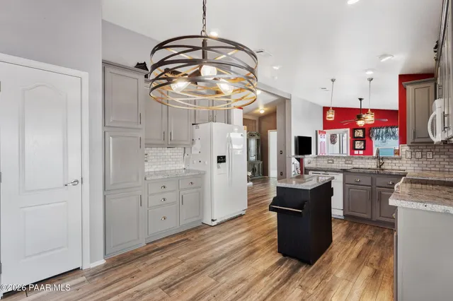 a kitchen with stainless steel appliances kitchen island granite countertop a stove a sink and a refrigerator