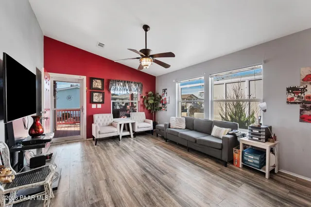 a living room with furniture flat screen tv and a large window