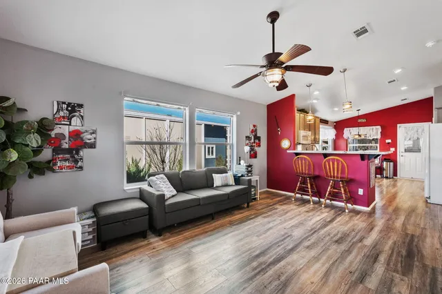 a living room with furniture ceiling fan and a window