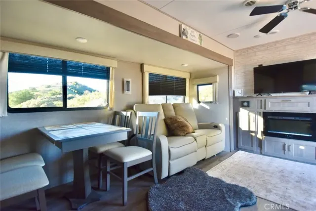a living room with furniture a flat screen tv and a large window
