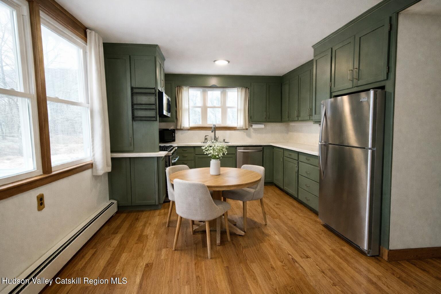 265 Scribner Hollow Road Hunter, NY 12442 - Photo 11 of 36 a kitchen with a table chairs refrigerator and window