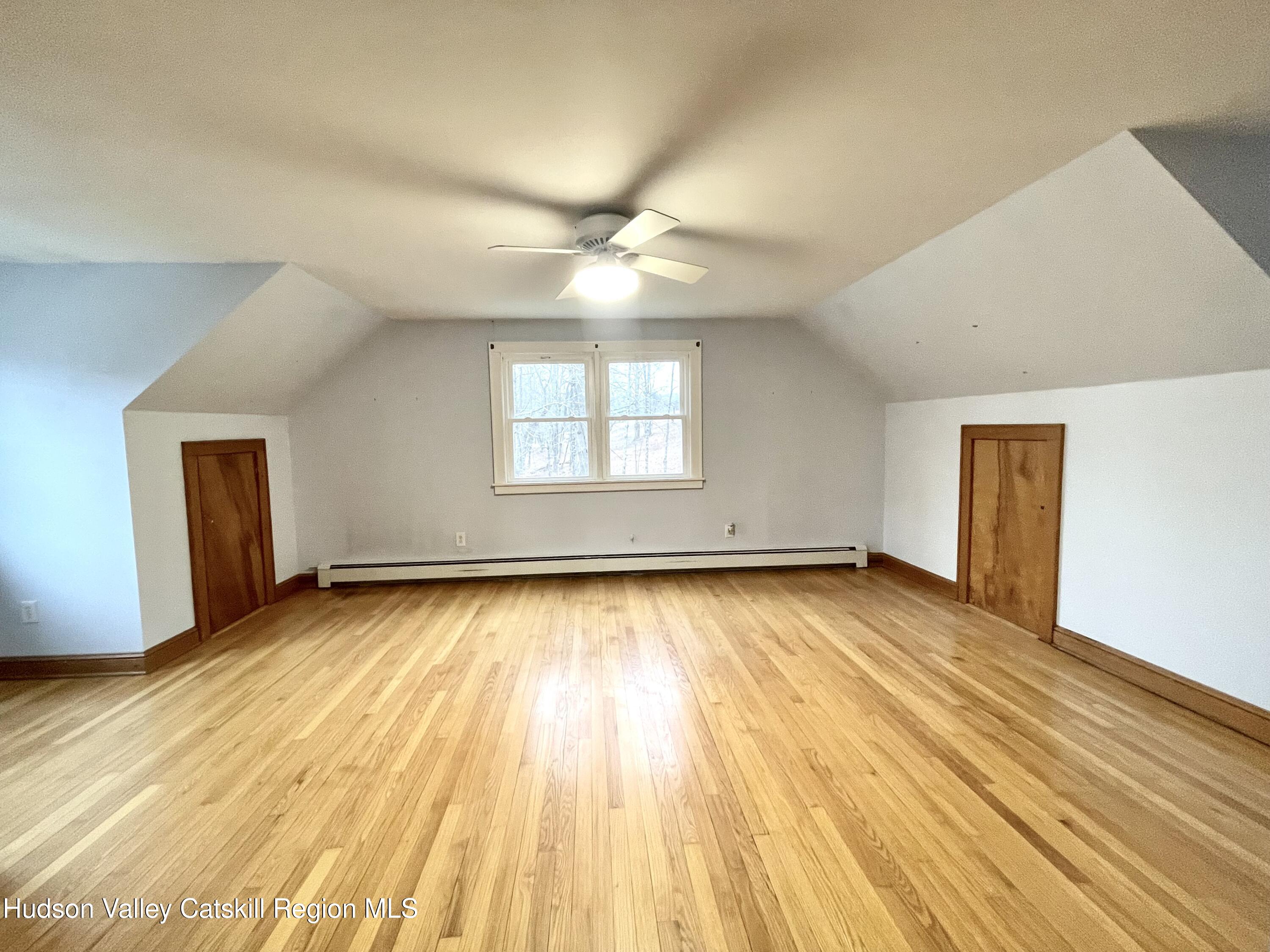 265 Scribner Hollow Road Hunter, NY 12442 - Photo 20 of 36 an empty room with wooden floor and windows