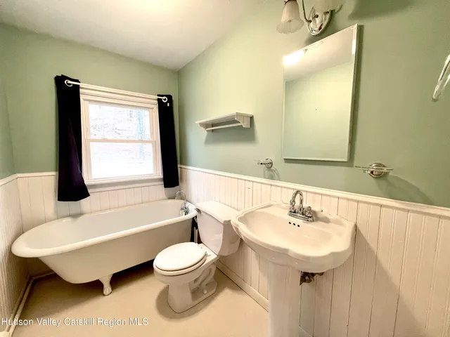 a view of an empty room with window and a kitchen