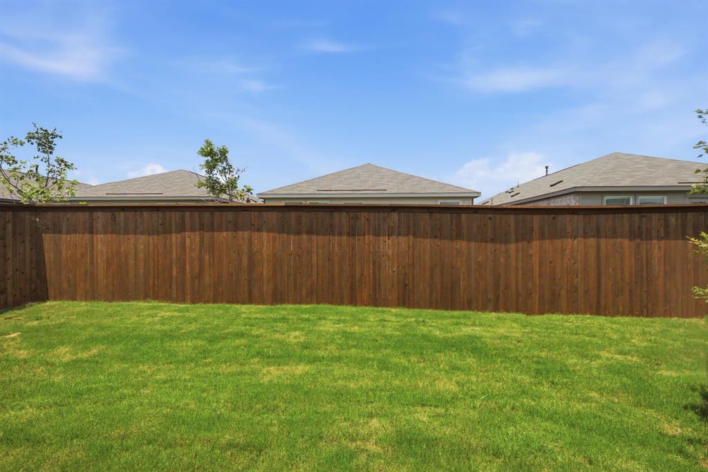 2128 Doc Holliday Road Joshua, TX 76058 - Photo 23 of 28 Expansive backyard featuring a lush green lawn and a tall privacy fence