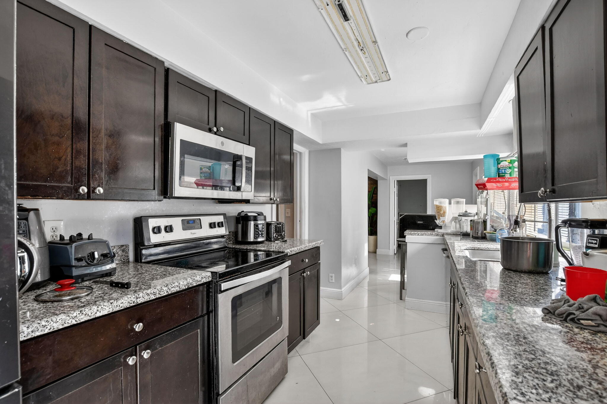 256 Southwest 11th Place Boca Raton, FL 33432 - Photo 19 of 43 a kitchen with stainless steel appliances granite countertop a stove a sink and a microwave