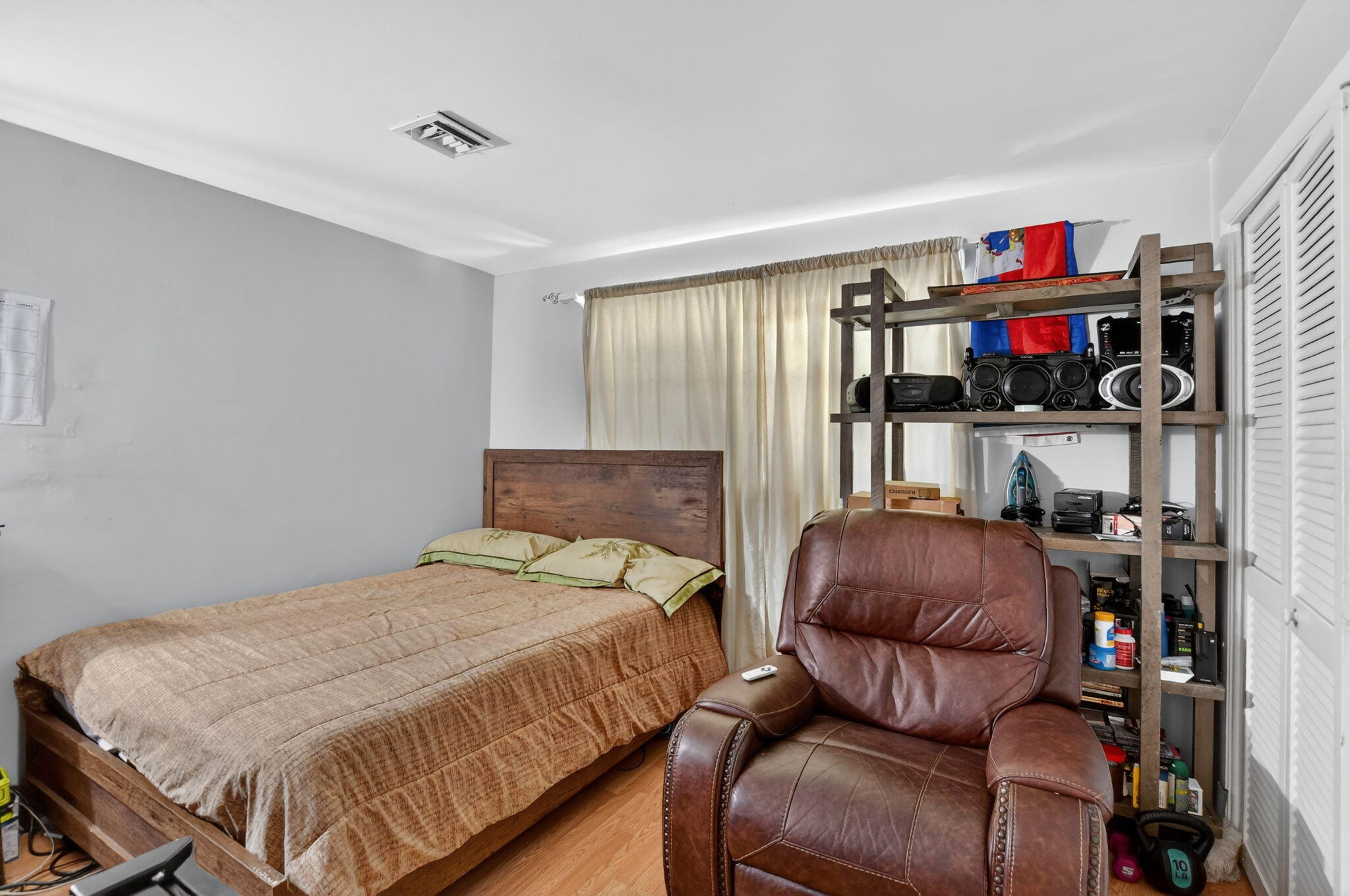 256 Southwest 11th Place Boca Raton, FL 33432 - Photo 25 of 43 a bedroom with a bed a couch and a flat screen tv