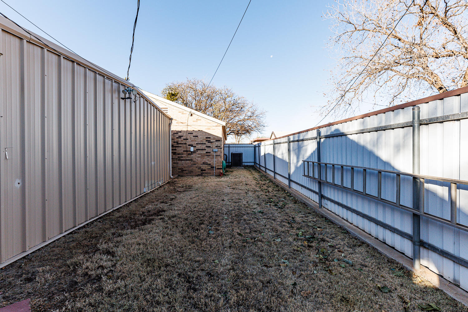 850 South 10th Street Slaton, TX 79364 - Photo 50 of 57 a view of a house with a small yard and wooden fence