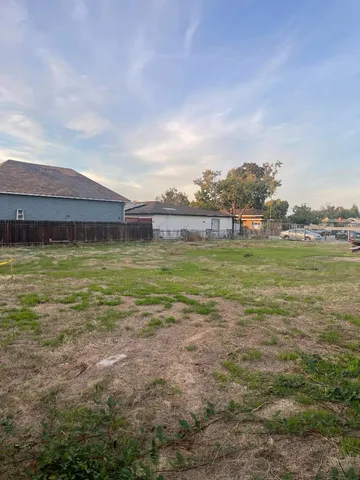 a view of a large pool with lawn chairs and plants