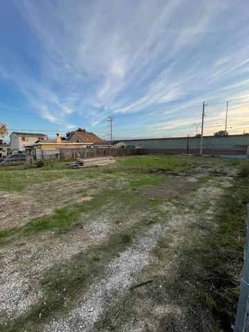 a view of a dry yard with wooden fence