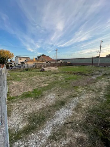 a view of a big yard with an empty space and a lake view