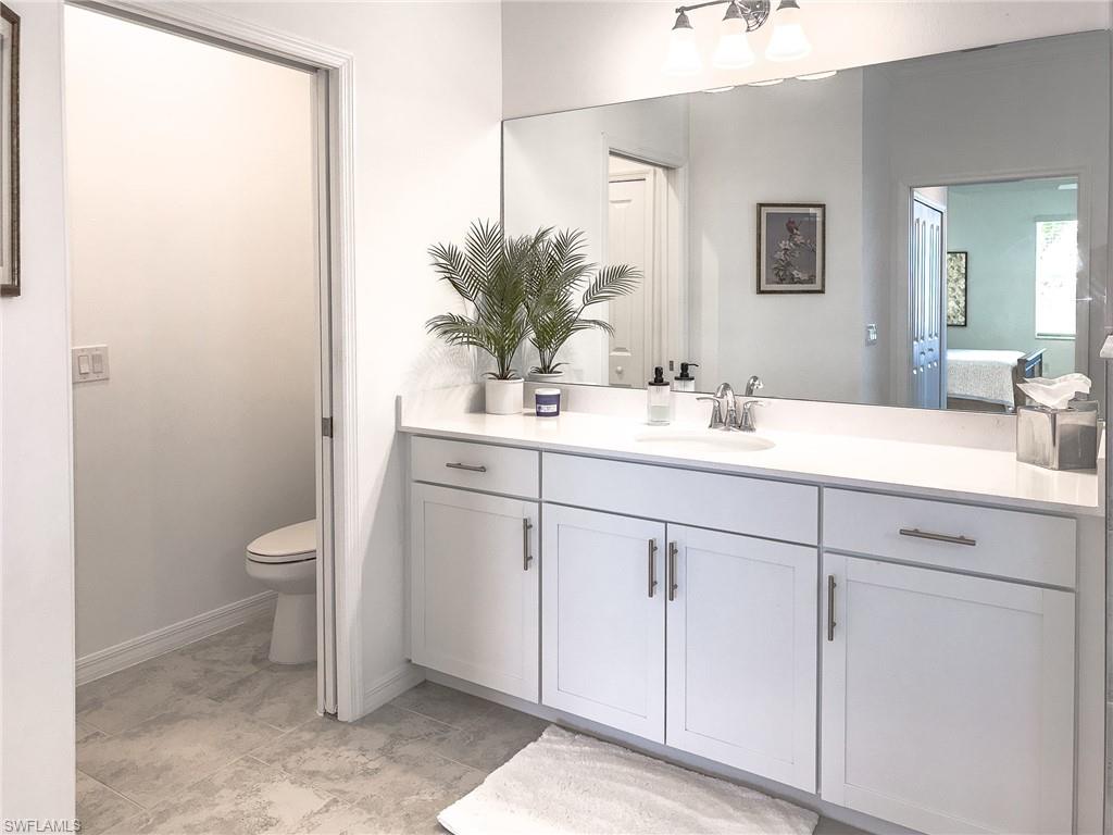 6012 Ellerston Way Avenue, Unit 1121 Immokalee, FL 34142 - Photo 17 of 50 a bathroom with a granite countertop sink a toilet and a mirror