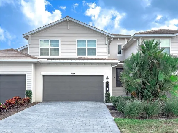 a front view of a house with a garden and a garage