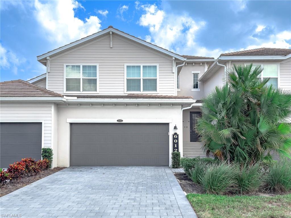 6012 Ellerston Way Avenue, Unit 1121 Immokalee, FL 34142 - Photo 2 of 50 a front view of a house with a garden and a garage