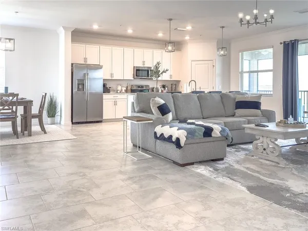 a living room with furniture and a view of kitchen
