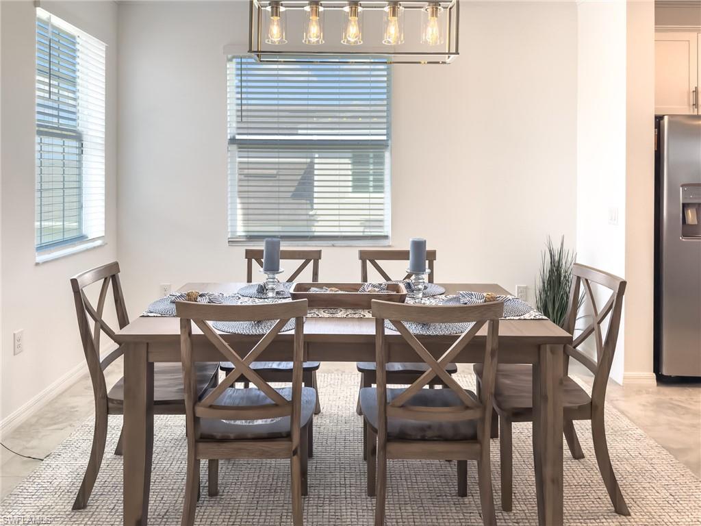 6012 Ellerston Way Avenue, Unit 1121 Immokalee, FL 34142 - Photo 9 of 50 a view of a dining room that has a table chairs and a wooden floor