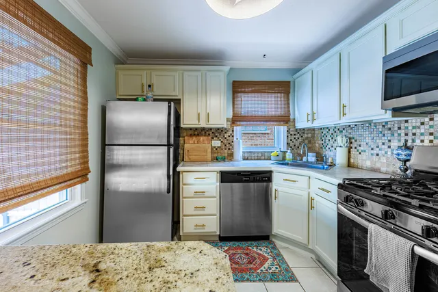 a kitchen with stainless steel appliances granite countertop a stove a refrigerator and a sink